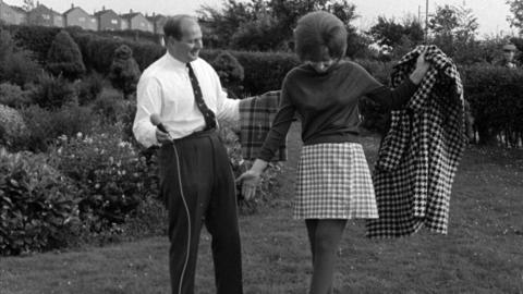 Evelyn Elliott wears a tartan 'mini kilt' next to Laird Portch.