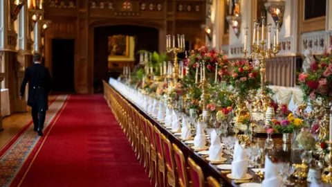PA Media A view of the banquet table, with gold candlesticks and lots of pink and red flowers