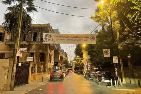 a street with a lebanese forces banner