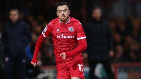 Jack Nolan running with the ball during a game for Accrington