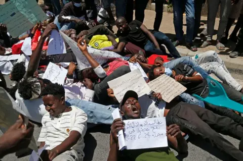 AFP Migrants hold placards during an anti-racism demonstration in the Moroccan capital Rabat on June 28, 2022.