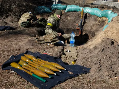 Getty Images A Ukrainian soldier with rocket launchers in a trench in Kyiv, 28 February 2022