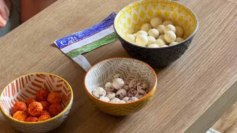 Chilli Pepper, basil and plain flavoured Qurt was displayed on a wooded table with a paper Uzbekistan flag. 