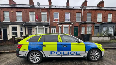 Pacemaker A police car parked outside a row of red brick terrace houses in Belfast eiqrtittiqzkinv