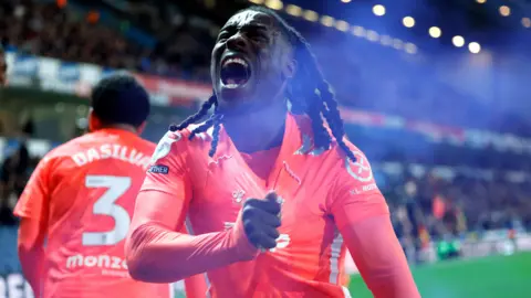 PA Media Brandon Thomas-Asante holds his shirt with pride