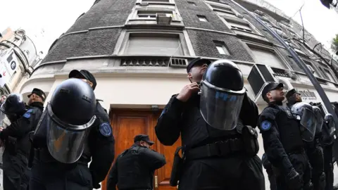 Getty Images Argentina"s Federal police officers guard the entrance of a building where former Argentine President and current senator Cristina Fernandez de Kirchner owns a flat