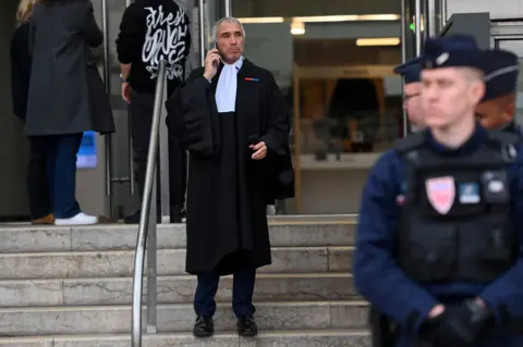 Reuters A man dressed in a lawyer's suit stands on the steps of a courthouse, talking on the phone