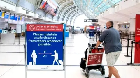 A man pushes a cart at an airport in Toronto