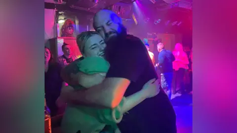 Juliette Murphy Philip and daughter Juliette. Man and younger woman hugging - appear to be at a bar