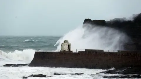 PA Waves crashing against cliffs in Portreath during Storm Eleanor