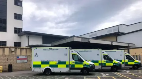 Three ambulances parked outside the entrance of the emergency department at Aberdeen Royal Infirmary.