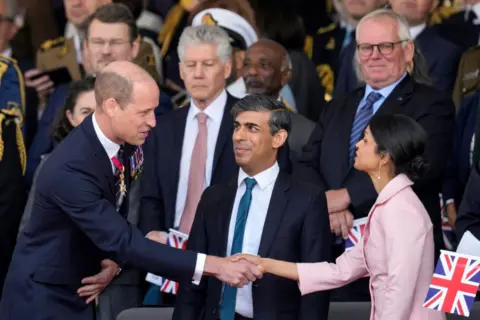 Kin Cheung/AFP Prince William shakes hands with Akshata Murty while Prime Minister Rishi Sunak looks on