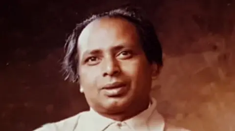 A man smiling softly in an old style photo