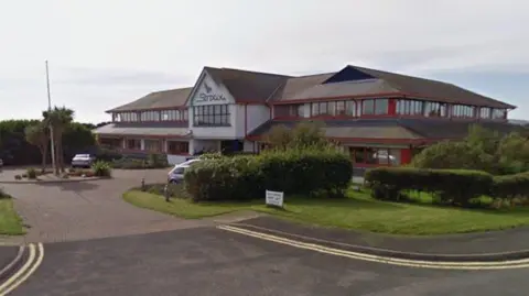 Google The headquarters building at Ronaldsway, which is a white two-storey building with red framed windows and Strix written above the entrance