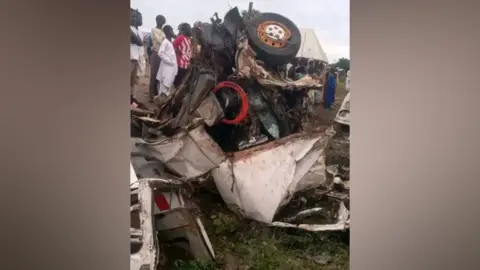 People looking at the crashed vehicle