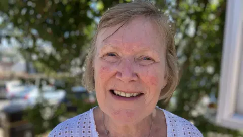 Jane Michie has short brown hair and is smiling at the camera.
