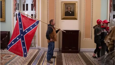 Getty Images Man seen carrying a Confederate flag in the US Capitol