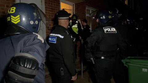 Police officers carrying out a drugs raid on a property in Hastings