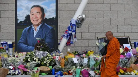 Getty Images A Buddhist monk lay tributes by a photograph of Leicester City Football Club's Thai chairman Vichai Srivaddhanaprabha outside the club's stadium