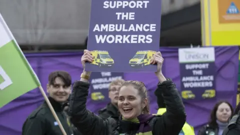 Getty Images Striking ambulance worker on a picket line in London on Wednesday