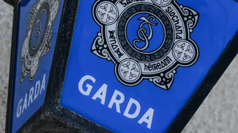 Getty Images A blue garda sign on a grey stone building. 