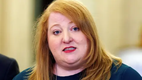 PA Media Naomi Long with red hair and a blue top.
