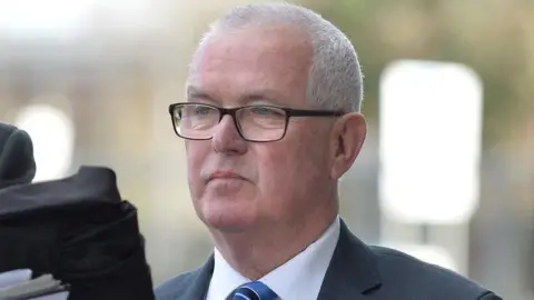 Spindrift A tight head shot of a tight-lipped Paul Mowat outside Glasgow Sheriff Court. He is wearing dark-rimmed glasses, a dark navy suit, white shirt and blue and white striped tie.