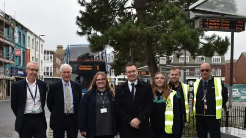 NELC People standing at a bus stop