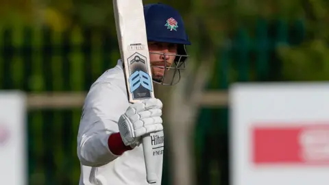 Lancashire's Paul Coughlin holding his bat in his right hand after scoring a half-century against Worcestershire.