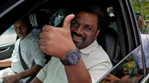 Reuters Sri Lanka's President Anura Kumara Dissanayake gestures as he leaves after voting in the capital Colombo