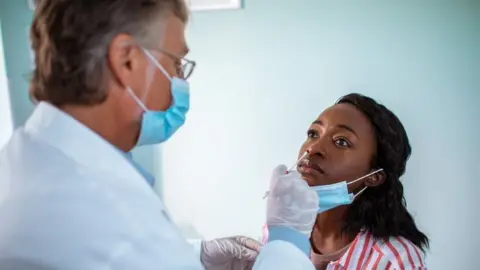 Getty Images Doctor performs a PCR test on a patient