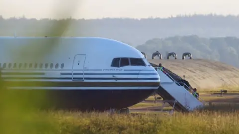 Reuters Members of the staff board a plane reported by British media to be first to transport migrants to Rwanda, at MOD Boscombe Down base in Wiltshire, Britain, June 14, 2022.