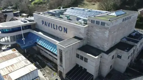 Argyll and Bute Council An image from a height of the Rothesay Pavilion mid-renovation. Its blonde stone looks freshly cleaned and blue plastic covers some of its windows.