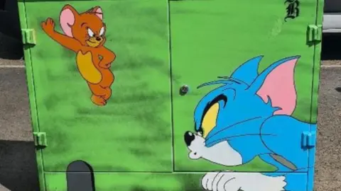 Tom and Jerry artwork. Tom looks cross as he hunts a smirking Jerry.
