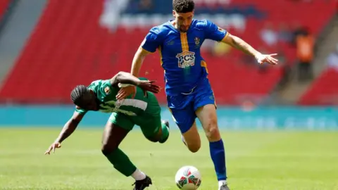 PA Media Opposing players fight for the ball