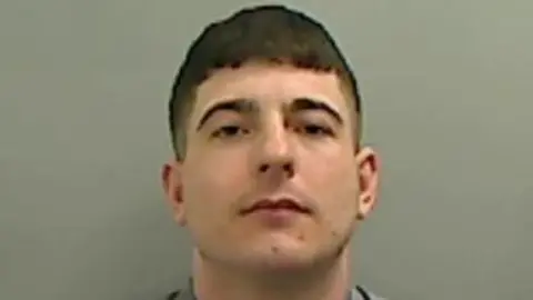 Cleveland Police Mugshot of Macauley Wright. He is clean shaven with a pale face and short dark hair