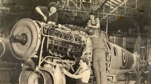 A sepia photo of women working on an aircraft.