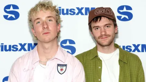 Getty Images The 2  set  members of Good Neighbours. Oli has abbreviated  blonde hairsbreadth  and Scott has abbreviated  brownish  hair. 