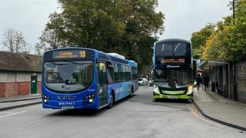 General view of two buses at a bus station in Cambridge.