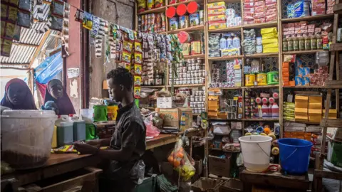 SOPA Images Customers shop at a store in Dollow, Jubaland, Somalia, where prices have risen significantly. People from across Gedo in Somalia have been displaced due to drought conditions and forced to come to Dollow, in the southwest, to search for aid. Somalia has suffered three failed rainy seasons in a row, making this the worst drought in decades, and 6 million people are in crisis levels of food insecurity. The problems are being compounded by the rising costs of food prices because of the Ukraine war. Hence, hundreds of thousands of livestock have died from hunger and thirst.