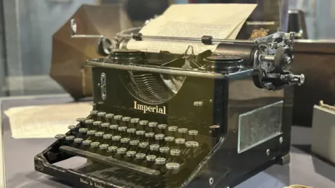 An old Imperial typewriter in a glass case.