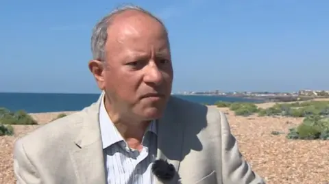 BBC Sami Sabet sitting on a beach