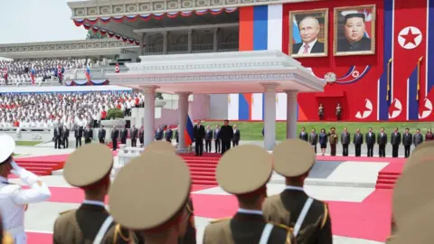 Sputnik / Getty Images In this pool photograph distributed by the Russian state agency Sputnik, Russia's President Vladimir Putin (centre L) and North Korea's leader Kim Jong Un (centre R) attend a welcoming ceremony at Kim Il Sung Square in Pyongyang on June 19, 2024. 