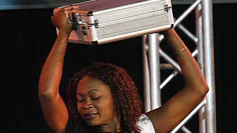 Getty Images Cherise Makubale, 24, dances with a briefcase containing around £76,000 after winning Big Brother Africa in 2003.