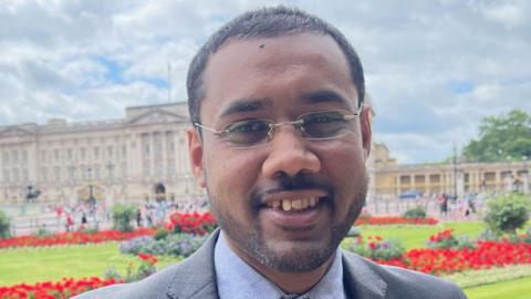 Mohammed Zaman standing outside Buckingham Palace