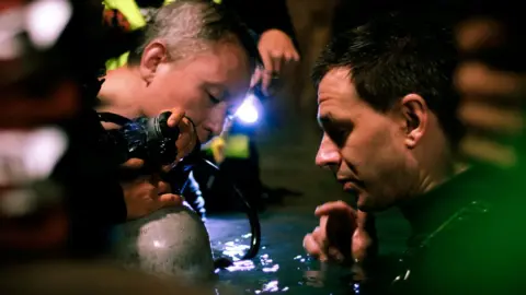 Fredrik Divall/De Warrenne Pictures Cave divers Tan Xiaolong and Jim Warny preparing for a scene