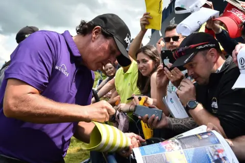 AFP Fans look on as Phil Mickelson signs a prostehtic leg at Royal Portrush