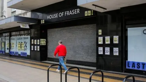 BBC A man walks past the closed House of Fraser shop in Middlesbrough