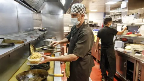 PA Media Food being prepared by a Chef in the kitchen at the Mumtaz restaurant in Leeds. They will be handing out free food boxes during half term for any child who would normally get a free school lunch after MPs voted to reject a motion to provide food to those in need during the school holidays.