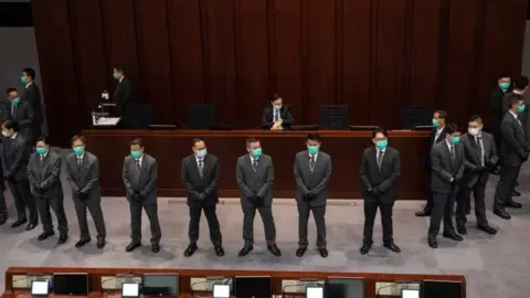 EPA Chan Kin-poor surrounded by guards